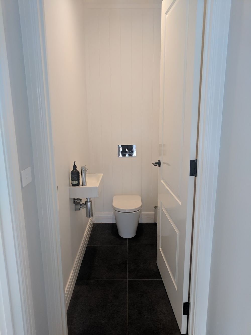 New wall-faced toilet and wall-hung basin in a powder room